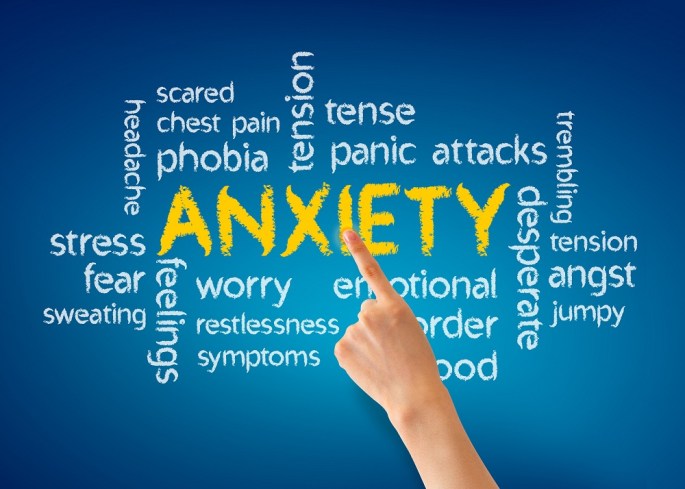 Hand pointing at a Anxiety word illustration on blue background.